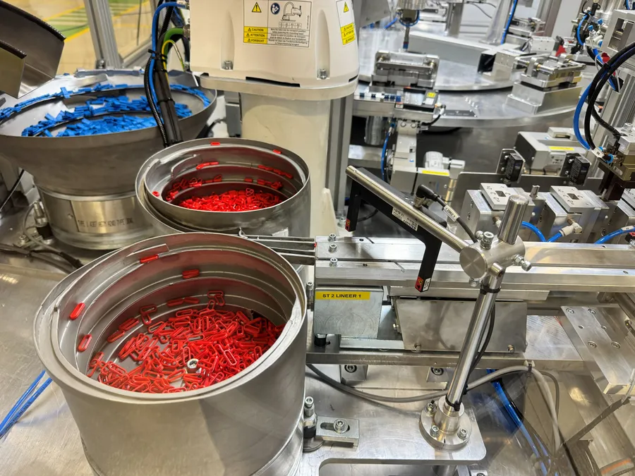 Montaj hattında üç çanak dizici ve lineer besleyici ile plastik klips besleme