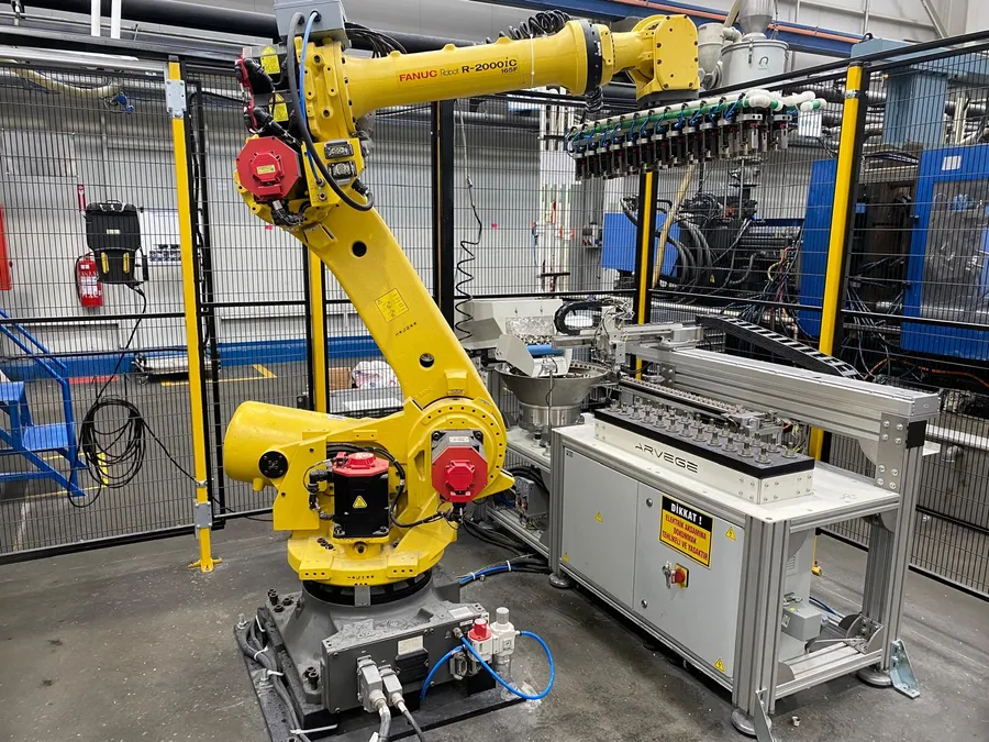 Enjeksiyon makinesi yanındaki robot hücresine Arvege besleme ünitesi ile parça besleme