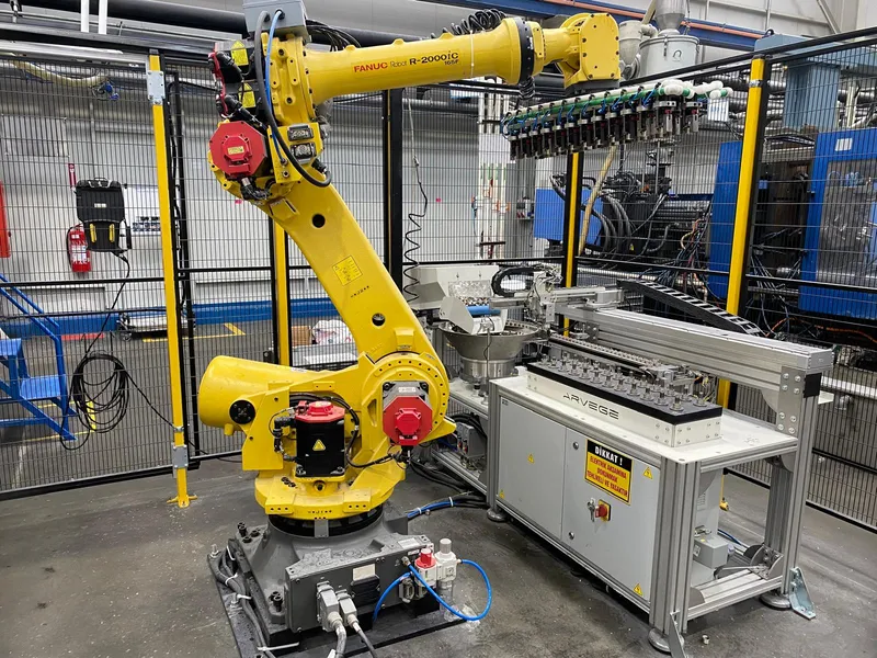 Enjeksiyon makinesi yanındaki robot hücresine Arvege besleme ünitesi ile parça besleme