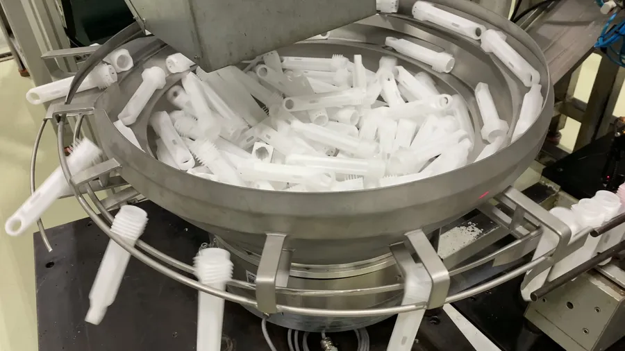 Konik çanak tipi vibrasyon dizicide beyaz plastik parçaların sıralanması